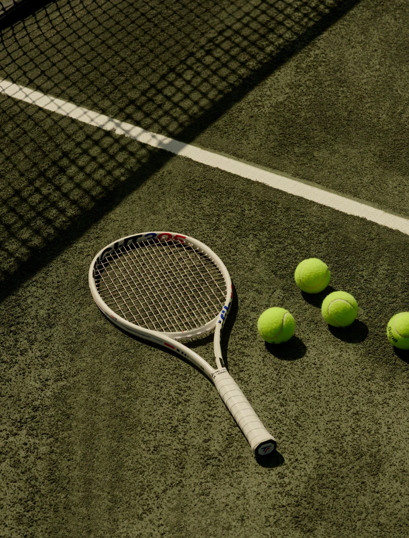 Racket and tennis balls on court — lifestyle reference
